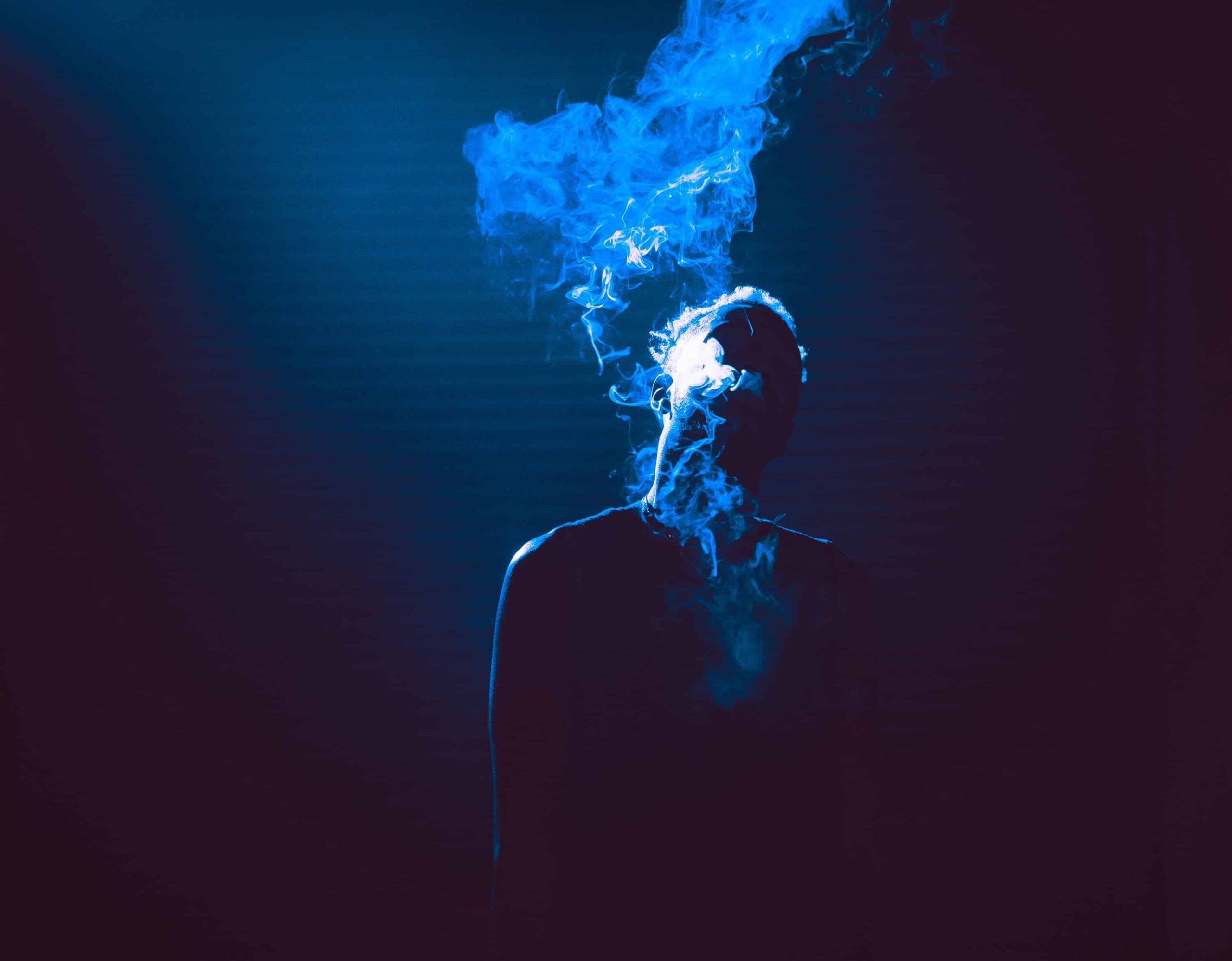 Person smoking a dark room.