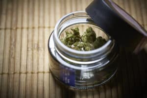 Marijuana cannabis: In glass jar bought from a legal dispensary retail, store on bamboo mat.